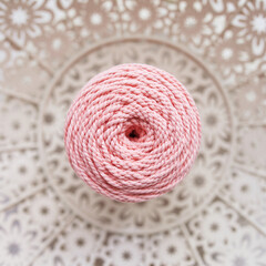 Handmade macrame braiding and cotton threads in basket on white background. Cotton macrame cords and ropes against wire basket. Good image for macrame and handicrafts banners and advertisement. 