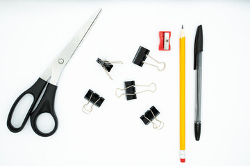 Pencil, pen, scraper, paper clips and scissors, on white background. School office supplies