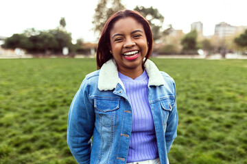 Portrait of friendly smiling hispanic latin american young adult woman looking at camera in city park. Youth