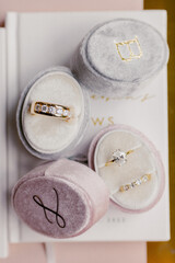 Stylish wedding rings with diamonds of groom and bride in soft ring boxes