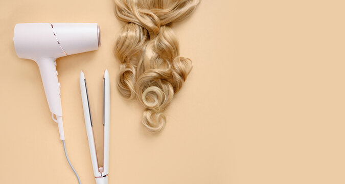 Straightener, hair dryer, styling and hairstyles for light brown curls. Blonde curls. Hairstyle.Hairdresser's tools.