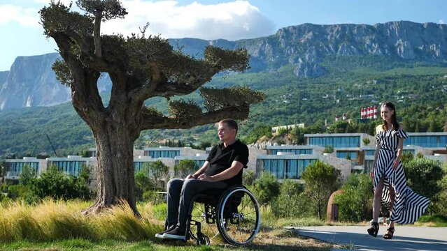 A woman hugs and kisses a man in a wheelchair for people with disabilities.