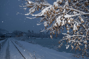 Snowfall and slippery road. Road safety in winter with snowfall. Winter cityscape. Small town street. Snow covered sidewalk. Urban landscape of a snowy street. Winter weather conditions on the road