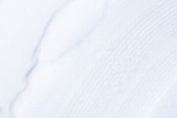 Obraz premium Cosmetic product foamy smudges top view. Smooth shaving foam texture close up. White foam grain.