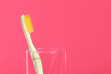 A cup with a toothbrush on the table on a colored background. Dental care. Background in the...