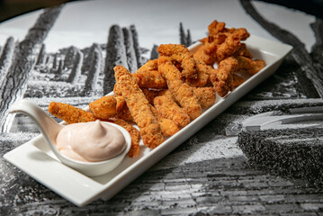 Fried chicken fingers with sauce on a plate