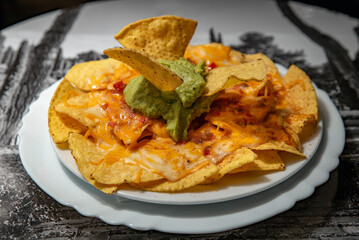 Nachos with cheese and guacamole on a plate