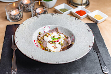 Veal tonnato vitello with sauce on a white plate