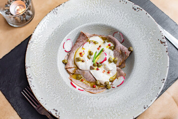 Veal tonnato vitello with sauce on a white plate