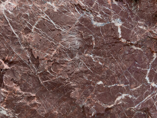 Fototapeta na wymiar The texture of the cut of natural stone. red-brown color with white streaks.