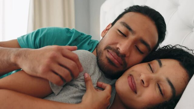 Love, morning and wake up with a black couple in bed cuddling in the bedroom of their home together. Sleeping, happy and smile with an affectionate man and woman hugging while bonding in a house