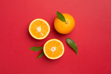 Flat lay with fresh oranges and leaves on color background