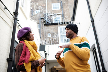 Two deaf friends are using sign language in a very narrow in London.
