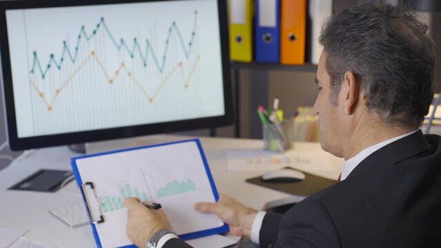 Mature businessman making a balanced analysis of the statements showing the year-end receivables status of the business.