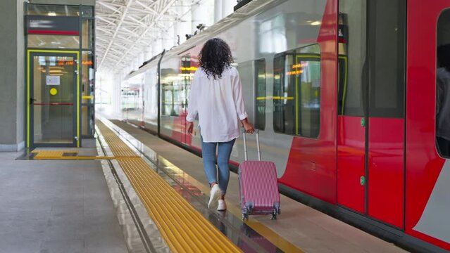 Girl traveler with luggage on station platform