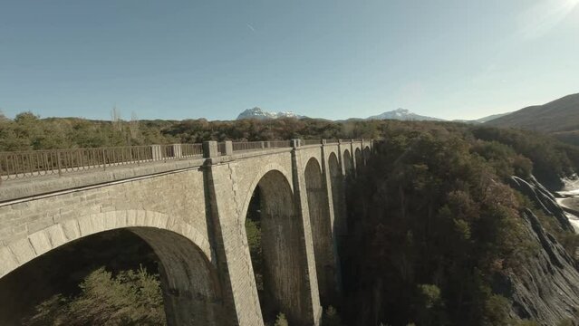 Car driving over an old stone bridge in the countryside