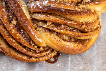 Roscón de reyes Kringle Estonia. Typical Christmas sweet, braided sponge cake with cinnamon, butter, walnuts or almonds and icing sugar on a white background.