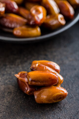 Dried dates fruit on black table.