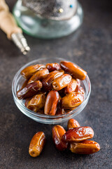 Dried dates fruit in bowl on black table.