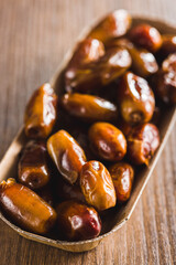 Dried dates fruit on wooden table.
