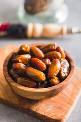 Dried dates fruit in wooden bowl.