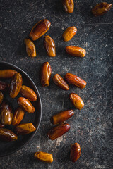 Dried dates fruit on black table. Top view.
