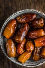 Dried dates fruit in bowl. Top view.