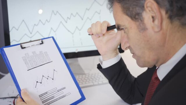 Mature businessman making a balanced analysis of the statements showing the year-end receivables status of the business.