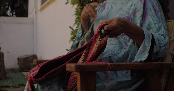 Detail of a Colombian indigenous woman from La Guajira weaving a handmade bag