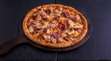 Hot meat pizza isolated on cutting board top view on dark background italian fast food