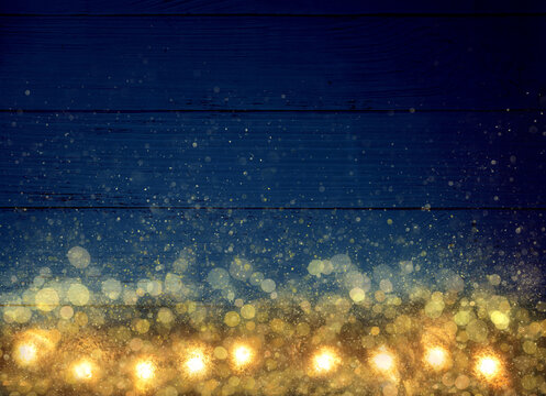 Magic Christmas golden lights bokeh effect on empty blue wooden table