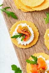 Overhead shot  of a finger food appetizer made of gluten free crisps with salmon and mustard