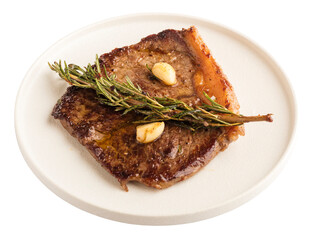 Grilled beef steak with a sprig of rosemary and garlic on a white plate. Isolated object on a transparent background. Close-up