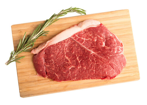 Fresh Raw Beef Steak And Rosemary Sprig On A Wooden Cutting Board. Isolated Object On A Transparent Background. Top View