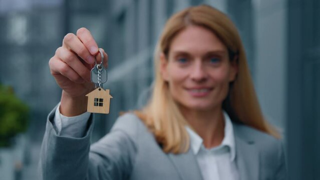 Focus on keys caucasian woman real estate agent businesswoman showing key to new house makes special offer affordable housing sells property happy homeowner rejoices in successful purchase apartment