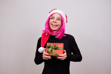 Woman with pink hair and a Christmas hat with a gift
