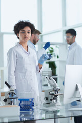 Smiling scientists looking at camera arms crossed in laboratory