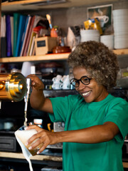 African American female waitress with afro hair serving a beer in a pub 