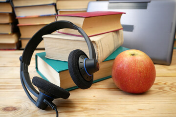 Headphones and many books on wooden background, Audio book concept. Online library archive.