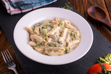 White creamy pasta served in dish top view on dark background american fast food