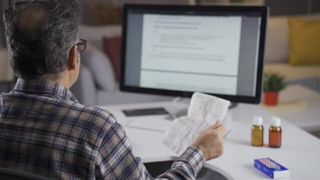 Sick man reading the medicine leaflet.
The old man reads the leaflets of the drugs he needs to use at home and gets information.
