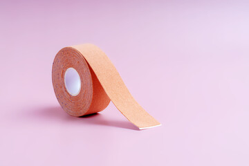 Cometic tape for skin tightening flesh color on a light pink background