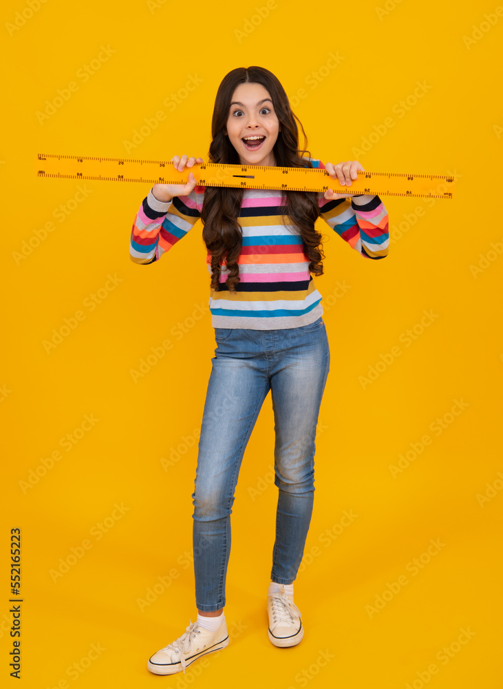 Poster amazed teenager. back to school. school girl hold ruler measuring isolated on yellow background. exc