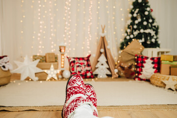 woman feet wearing christmas shoes indoor over christmas decoration