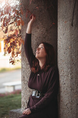 An attractive young woman with a sad pensive expression in a park on a sunny day. Shallow depth of field female creative portrait