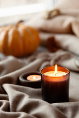 Obraz na płótnie Canvas warm cozy window arrangement, winter or autumn concept, candles throw pumpkin
