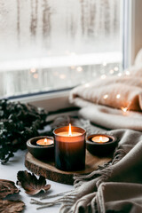 warm cozy window arrangement, winter or autumn concept, candles throw lights