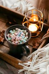 warm cozy bedroom winter or autumn concept, cup of hot chocolate on tray, candles throw
