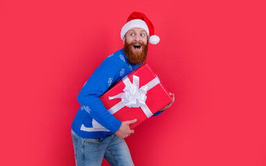 surprised man in santa claus red hat with new year present. new year sale. santa man hurry up