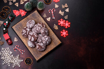 Delicious fresh brownies with Christmas decorations on a dark concrete background